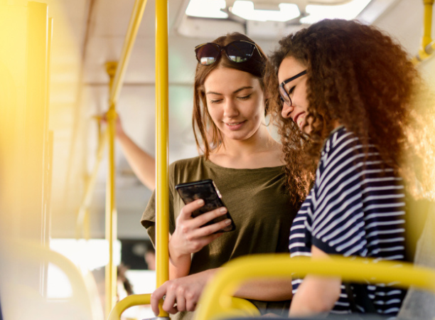 Two girls looking at phone inside DB Regio Bus