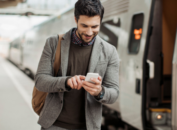 A man looking at this phone while boarding a train