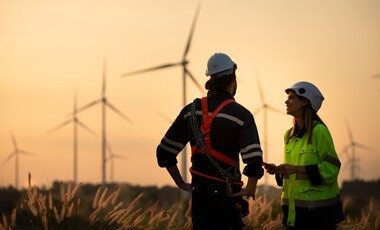 windmill workers with windmills in the background