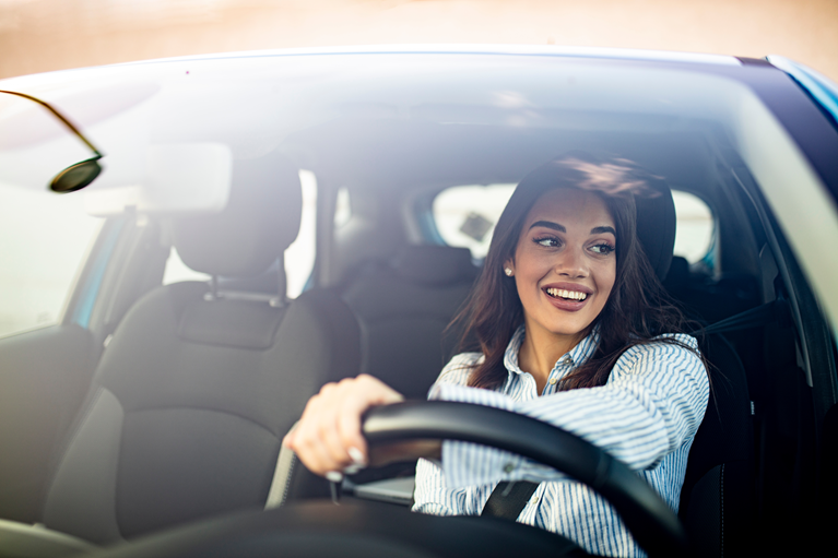 A happy woman driving a car