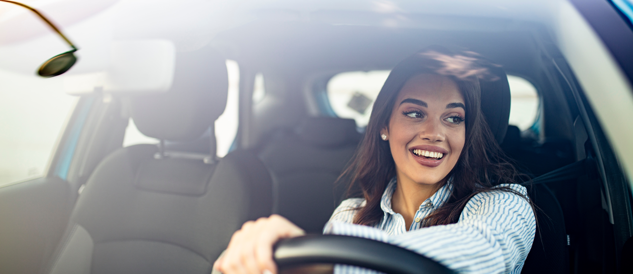 A woman happily driving a car