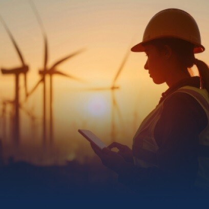 An engineer working on phone with windmills far away