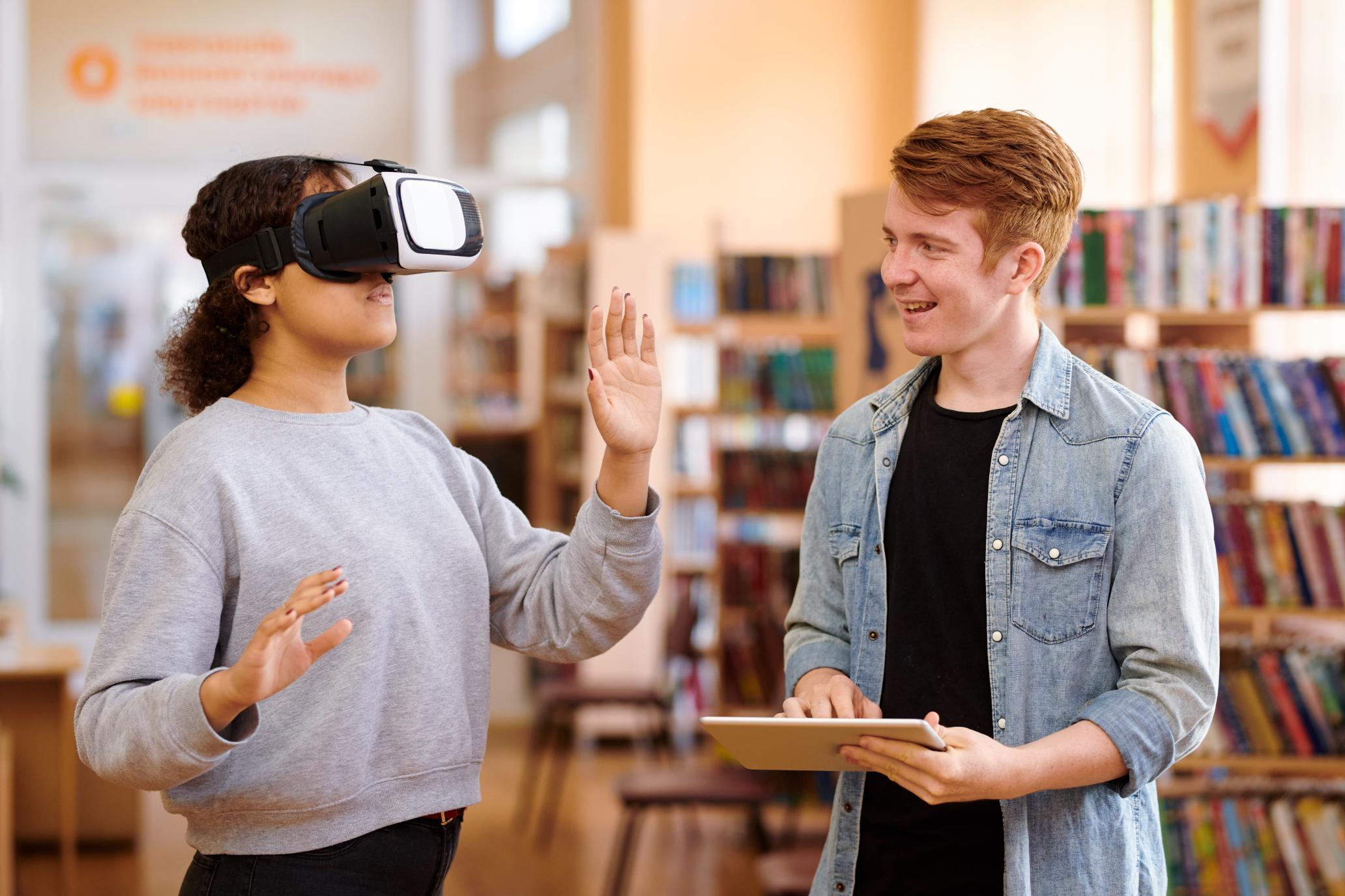 A girl wearing VR and a boy controlling with tablet