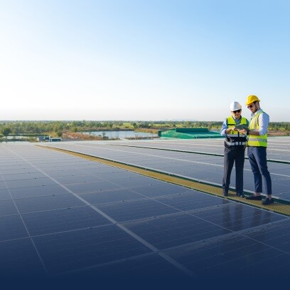 Two engineers working on a tablet standing around solar pannels